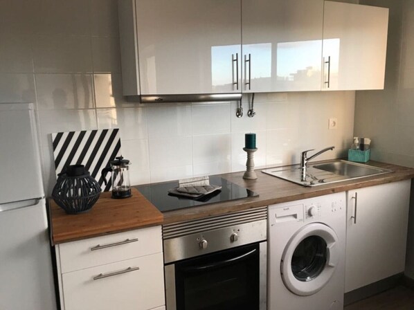 Modern kitchen with stainless steel appliances, oven, and a spacious countertop.