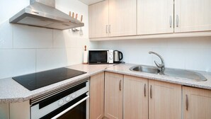 Une cuisine moderne équipée d’une cuisinière, d’un four à micro-ondes et d’un évier intégrés.