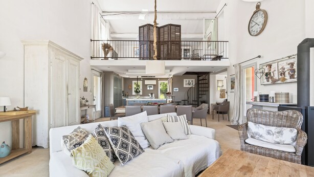 A spacious living area with a sofa, a dining table, and a balcony with a railing. - LARGE HOUSE, GORDES , heated swimming pool , view over Goult, Roussillon (Joucas)