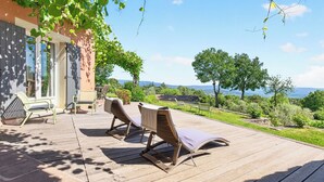 A wooden deck with outdoor seating and a view of the landscape. - LARGE HOUSE, GORDES , heated swimming pool , view over Goult, Roussillon (Joucas)
