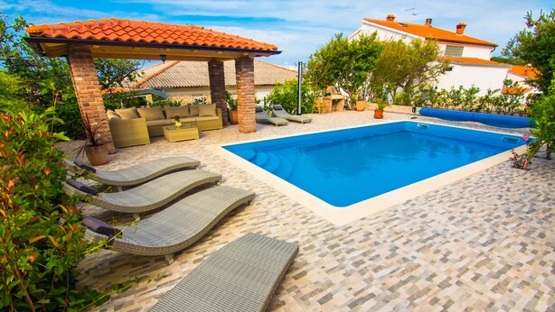 A swimming pool with lounge chairs and a covered seating area. - Nice and fresh two with sea views, large balcony and pool access. (Rab)