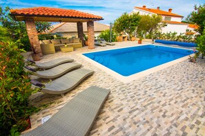 A swimming pool with lounge chairs and a covered seating area. - Nice and fresh two with sea views, large balcony and pool access. (Rab)