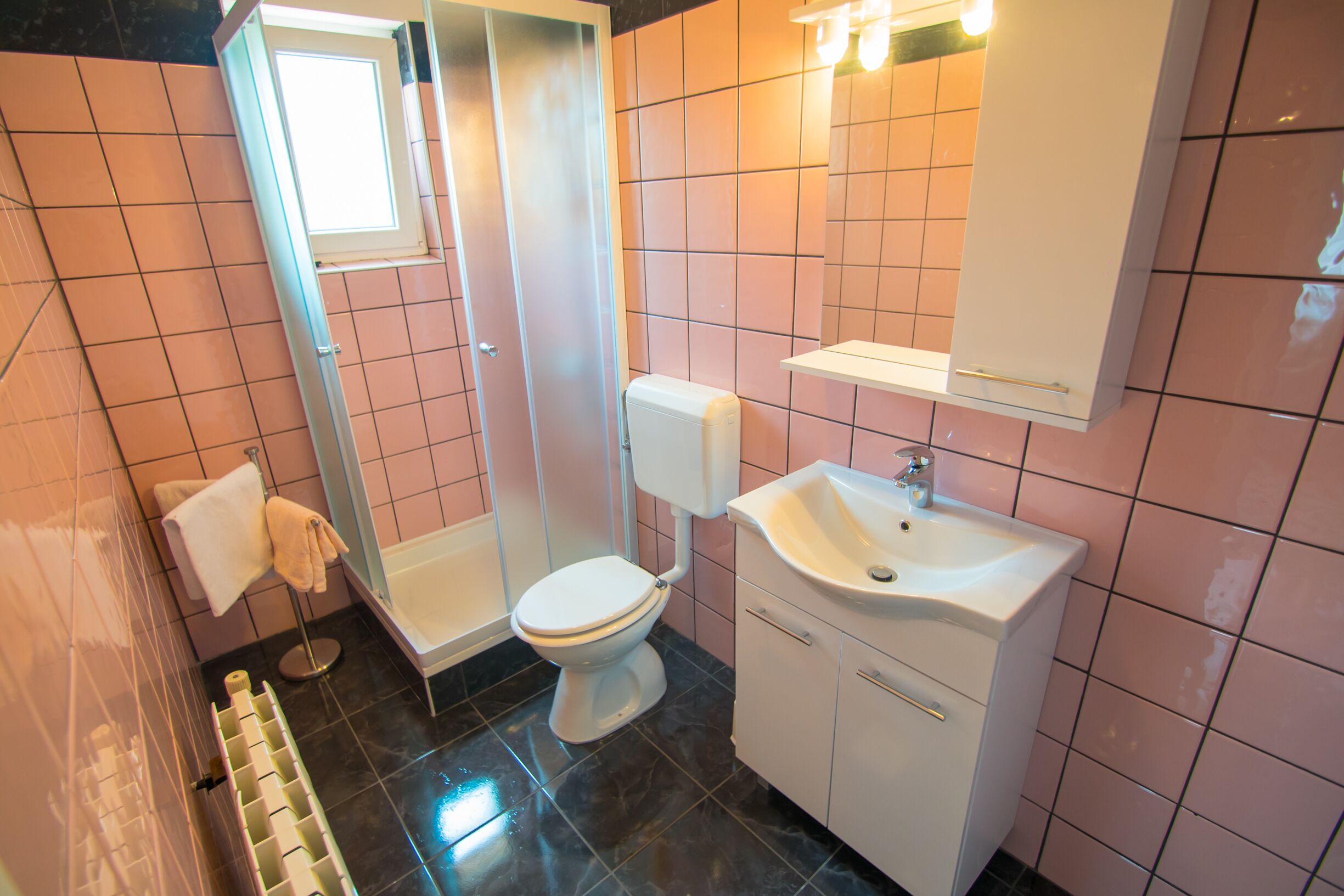 A bathroom with a toilet, sink, and shower.