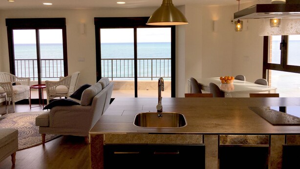 A modern kitchen with a large island, a dining area with a view of the sea, and a seating area with a view of the ocean. - SEAVIEWS Apartment - Beachfront Apartment (Torrevieja)