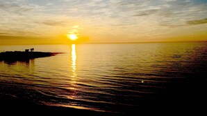 A sunset over a calm body of water with a pier extending into the water. - SEAVIEWS Apartment - Beachfront Apartment (Torrevieja)