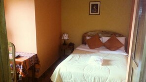 A small, cozy room with a single bed, a nightstand with a lamp, and a table with a tablecloth. - Hotel-Hostal Chachapoyas (Chachapoyas)