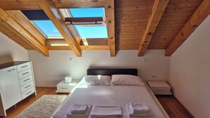 A bedroom with a bed, a nightstand, a dresser, and a skylight. - Villa Dubrovnik with pool and sea view (Dubrovnik)