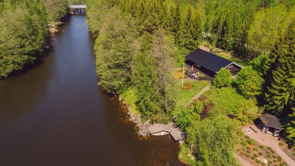 A riverside property with a dock, a bridge, and a cabin.