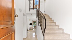 Eine Treppe mit schwarzer Metallgeländer, die zu einer oberen Etage führt.