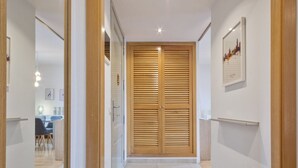 A hallway with a wooden door, a framed picture on the wall, and a light fixture. - SibsBcn- Balmes - Romantic Central Cozy (Barcelona)