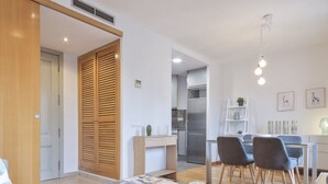 A modern living room with a glass coffee table, a sofa, and a dining area with chairs. - SibsBcn- Balmes - Romantic Central Cozy (Barcelona)