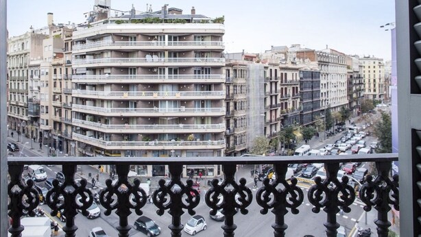 A multi-story building with balconies, a busy street below, and a clear sky. - SibsBcn- Balmes - Romantic Central Cozy (Barcelona)