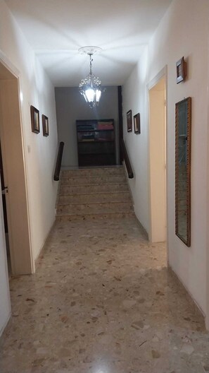 Ein Flur mit einer Treppe, die zu einer Zwischenebene führt.