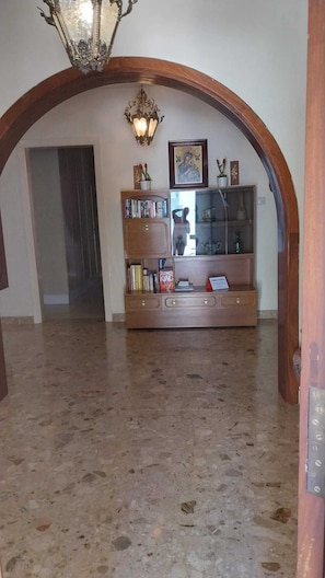 A lobby with a wooden bench, books, a glass display case, and a chandelier. - Sundecked Garden Villa near Mellieha Sandy Beach & main amenities. Top location. (Mellieha)