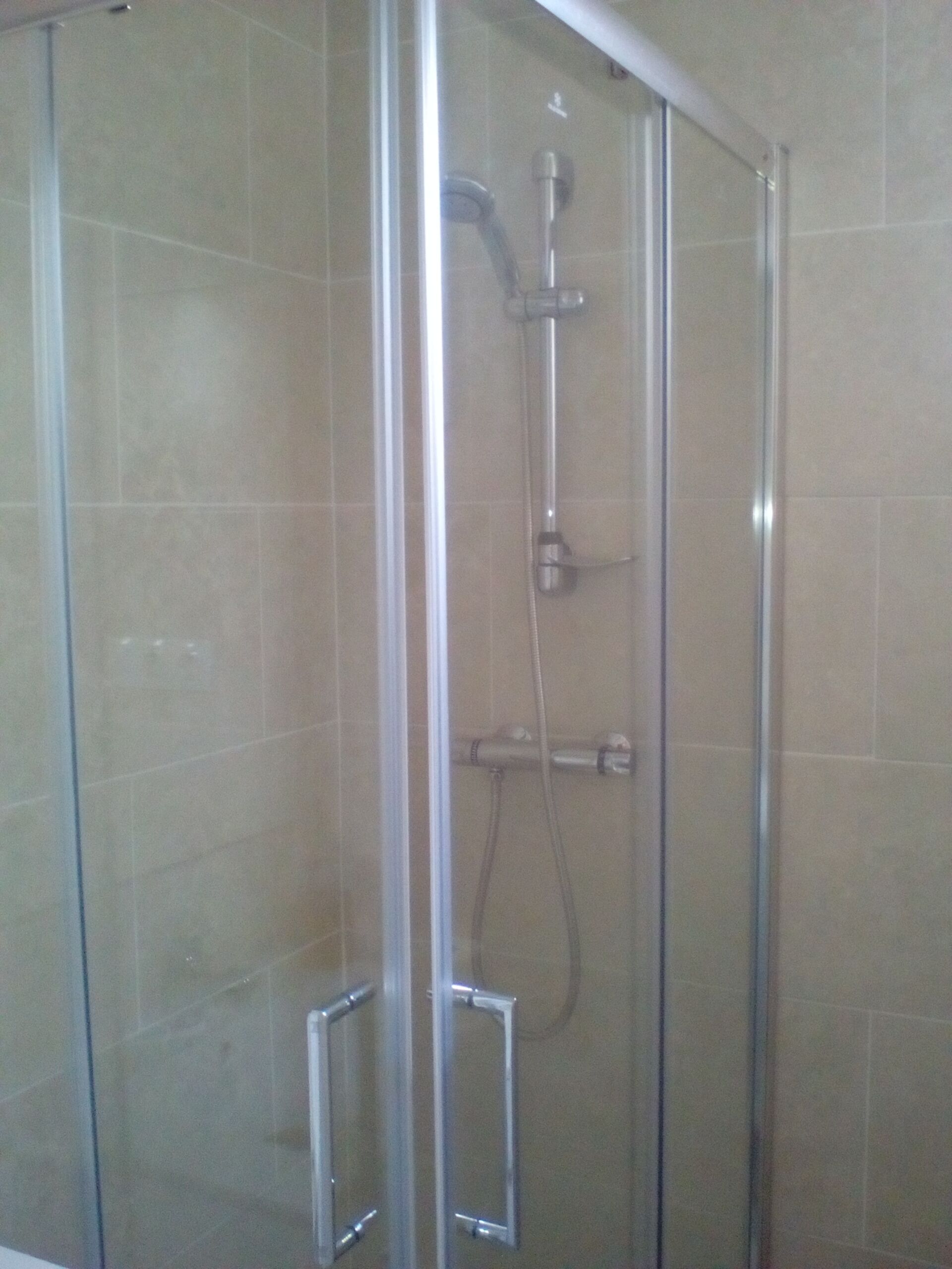 Regadera, secadora de cabello, toallas, papel de baño 