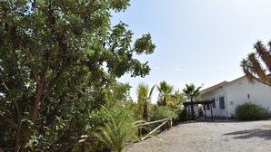 Un bâtiment avec une allée gravillonnée et une clôture en bois.