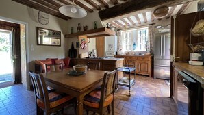 A cozy kitchen with a wooden dining table, chairs, and a hanging light fixture. - A pastoral setting within reach of seaside (12-25 kms) - Sleeps 6-8 (Manneville-La-Raoult)