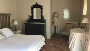 Quarto com cama, penteadeira, cadeira e mesa.