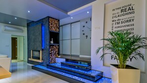 Un interior modern amb una escala de vidre, un rellotge de paret i una frase motivadora.