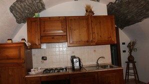 Une cuisine avec des meubles de rangement en bois, une cuisinière à gaz, un évier et un lave-vaisselle.