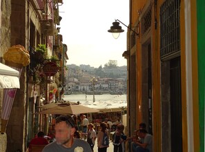A bustling street scene with a view of a river and buildings in the background.