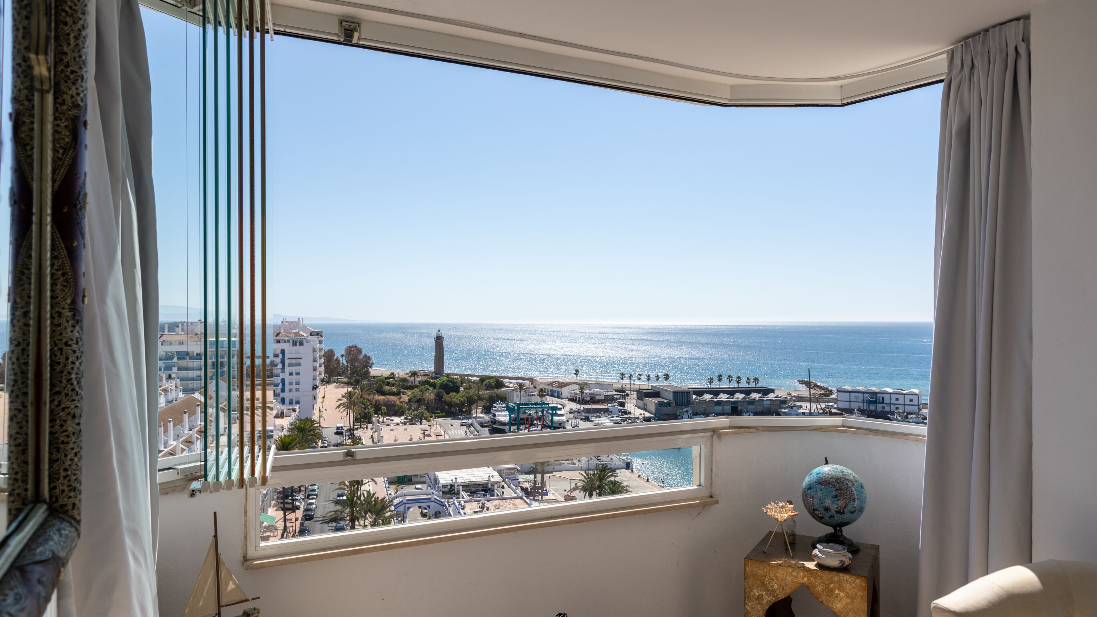 Un balcon avec vue sur la mer et les bâtiments.