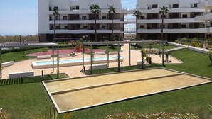 Un hotel moderno con diversi piani, un cortile centrale con piscina e vegetazione circostante.