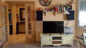 A living room with a TV, a clock, and a bookshelf. - La Cuesta Blanca House or chalet (Castilla de la Mancha)