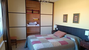 A bedroom with a bed, a nightstand, a dresser, a wardrobe, and a radiator. - La Cuesta Blanca House or chalet (Castilla de la Mancha)