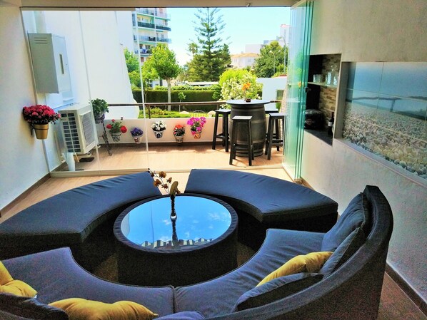 A modern outdoor seating area with a round table and cushioned seating.