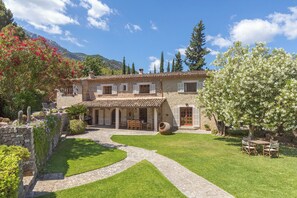 A stone house with a tiled roof, a covered patio, and a garden with a winding path. - Beautiful Country Villa With Private Pool & Huge Garden (Sóller)