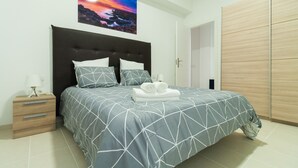 Une chambre à coucher comprenant un lit, une table de chevet, un tableau accroché au mur et une armoire.