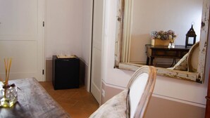 Une pièce comprenant une table à manger en bois, une chaise, un petit meuble, un miroir et un luminaire fixé au mur.