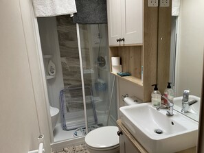 Chuveiro, secador de cabelo, sabonete, papel higiênico