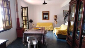 Une pièce comprenant une table à manger, un canapé, un meuble et une fenêtre donnant sur un paysage agréable.