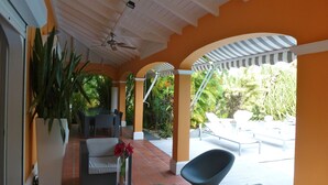 A covered outdoor seating area with a table, chairs, and a potted plant. - House / Villa - SAINT FRANçOIS (Saint François)
