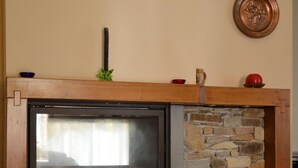 A stone fireplace with a television screen, a wooden mantel, and two decorative plates on the wall. - Villa with private pool in Lucca, special offers! (Capannori)