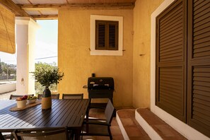 An outdoor patio with a table, chairs, a grill, and a potted plant. - CAN NOVES-Fabulous villa in a central and quiet area (Sant Francesc de Formentera)