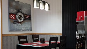 A modern dining area with a rectangular table, black chairs, and a pendant light.