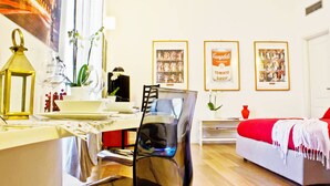 Una sala de estar moderna con comedor, un sofá rojo y cuadros en la pared.