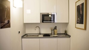 Cocina compacta con horno integrado, pileta de acero inoxidable y bloque para cuchillos.
