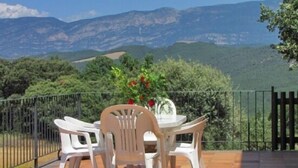 A terrace with a table and chairs, overlooking a mountainous landscape. - Apartment 4 guests in Casa Serra de Dalt (Lladurs)