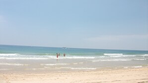 Una playa con cielo despejado y mar tranquilo.