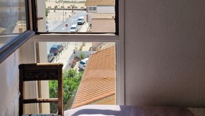 Un dormitorio con vista al mar, una silla y una cama.
