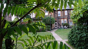A residential building with a well-maintained lawn, a pathway, and a small garden area. - Large sunny fresh two bedroom apt in London ideal for tourists, refurbished  (London)