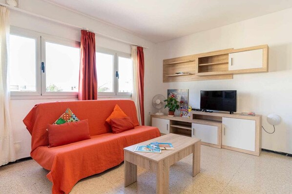 A living room with a sofa, a coffee table, a TV, and a small cabinet. - Fragata - Centro de Corralejo, playas, restaurantes y ambiente (Corralejo)