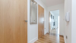Un pasillo con puertas de madera y una pared blanca.