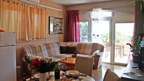 Un salón acogedor con sofá, mesa de comedor y zona de cocina.