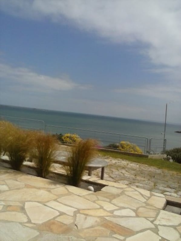 A stone patio with a view of the sea.