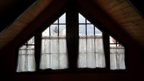 A room with a sloped ceiling and a large window with multiple panes.